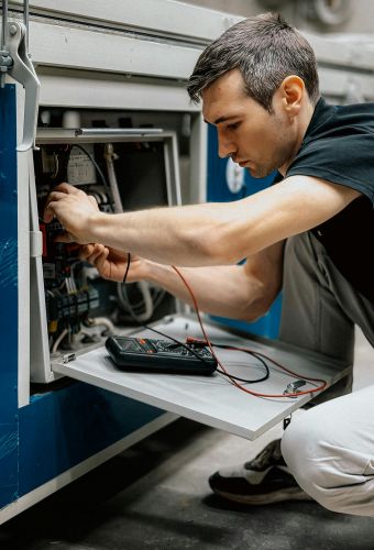 electrician checking safety of electrical oven 
