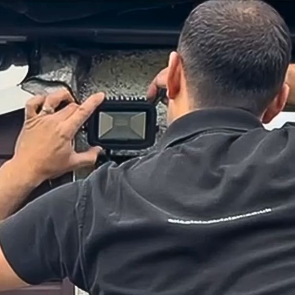 Electrician installing an outdoor security lighting